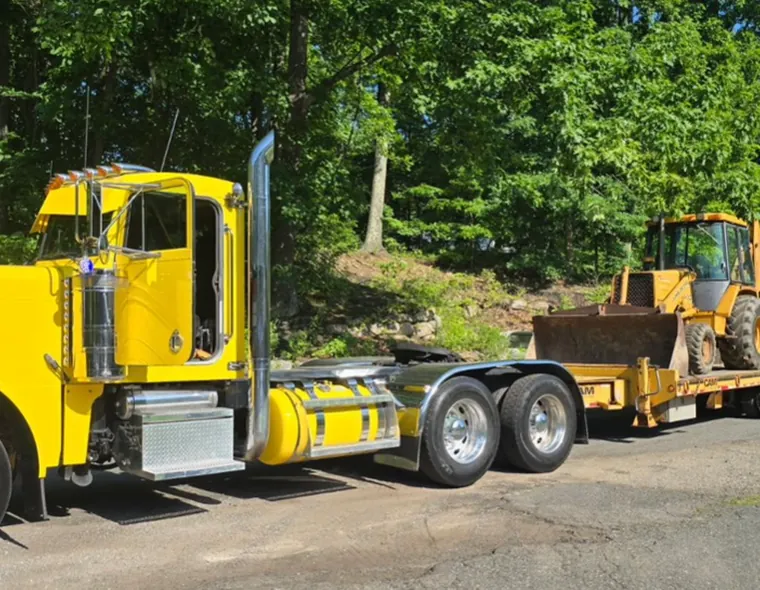 Backhoe loader on a trailer ready for site preparation
