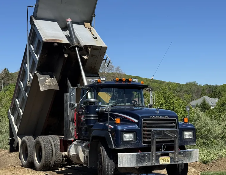 Aaron Excavating dump truck hauling soil from a site work project