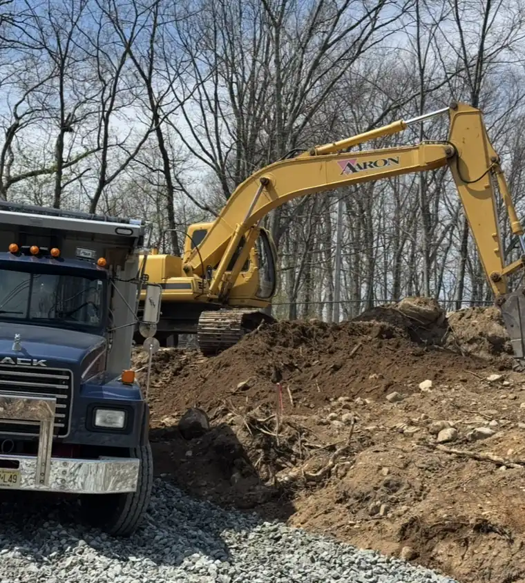 Aaron Excavating excavator and dump truck on a site clearing job