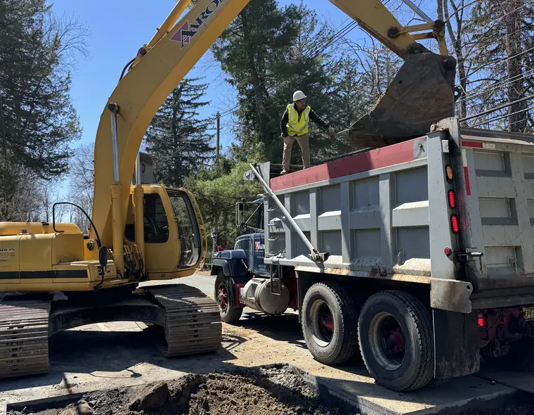Aaron Excavating digging a trench for sewer line installation and loading a dump truck